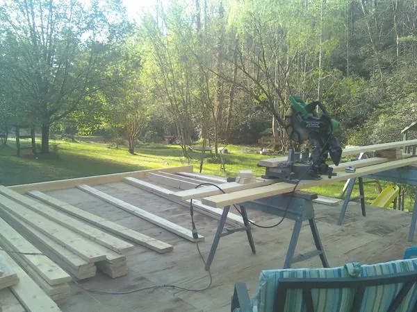 Miter saw and framing lumber on a deck under construction in Arlington
